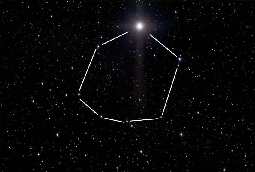 La galaxie spirale M106 visible dans la constellation des Chiens de Chasse, entourée de plusieurs étoiles faibles.