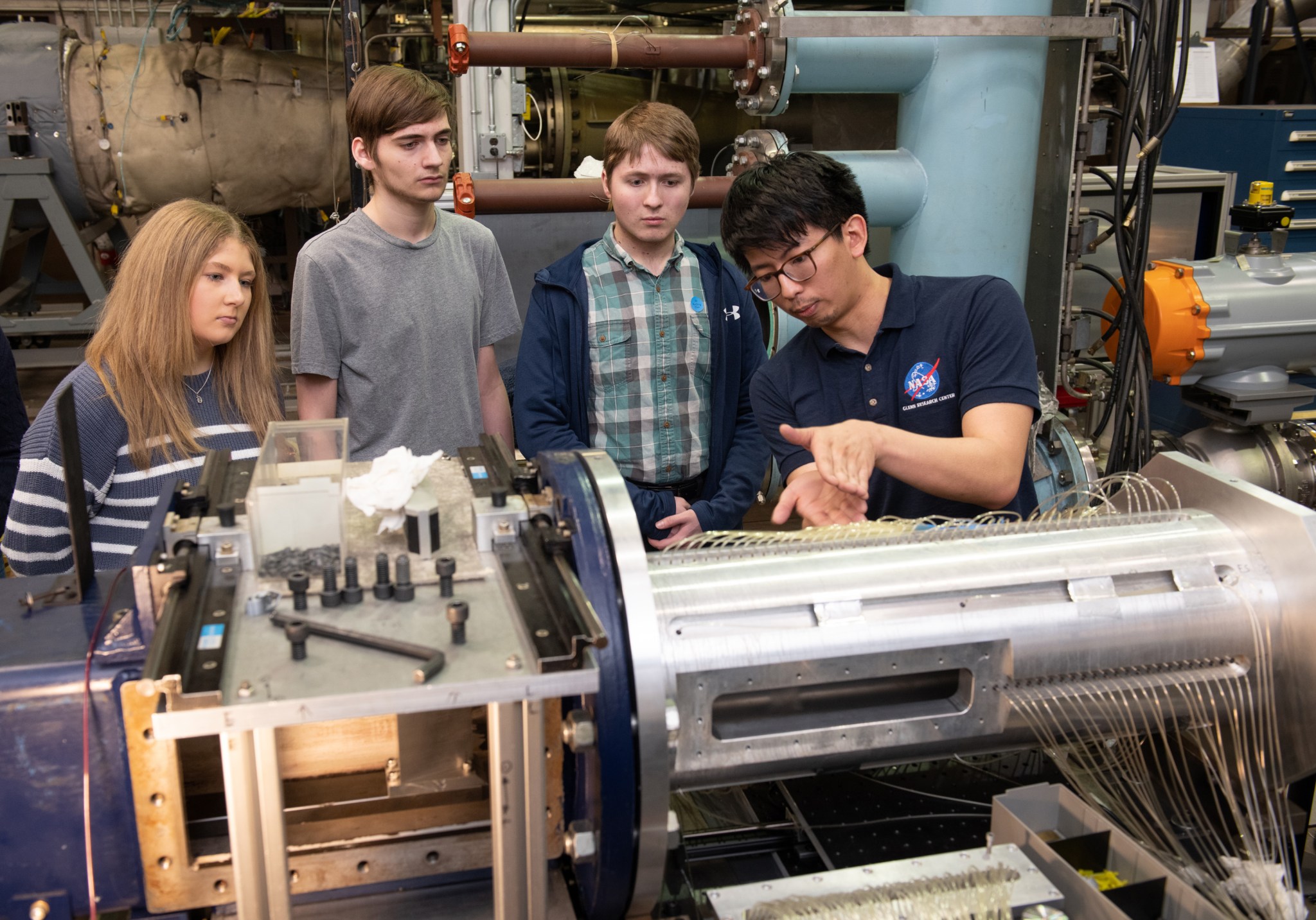 Groupe d'étudiants travaillant avec enthousiasme sur un projet de conception aéronautique lors d'un défi NASA.