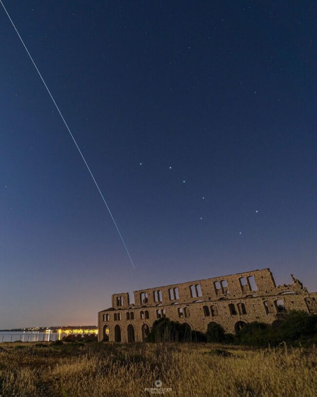Une personne observant le ciel nocturne avec un télescope portable pour repérer la Station Spatiale Internationale.