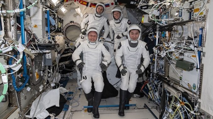 Mike Fincke en tenue d'entraînement avec des équipements Boeing Starliner, regardant une maquette du vaisseau.