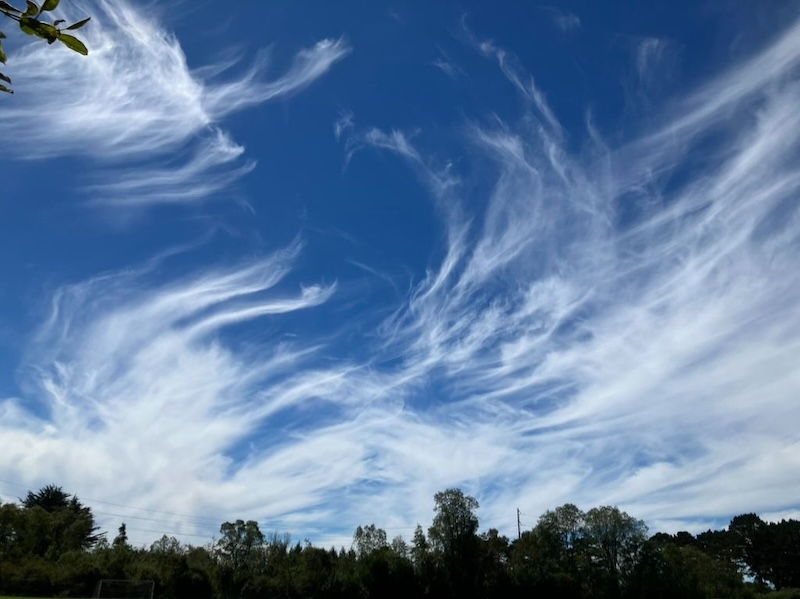 Vue aérienne d'une formation de nuages lenticulaires au-dessus d'une chaîne de montagnes.
